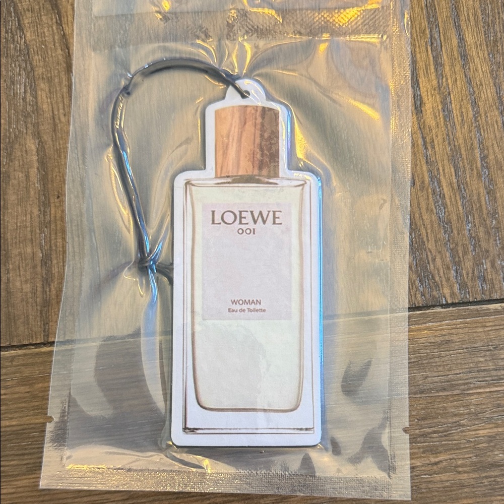 Loewe bottle-shaped air freshener in cream with wood-tone cap